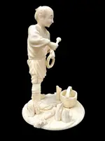 Scultura okimono in avorio raffigurante personaggio maschile con treccia e cesto.