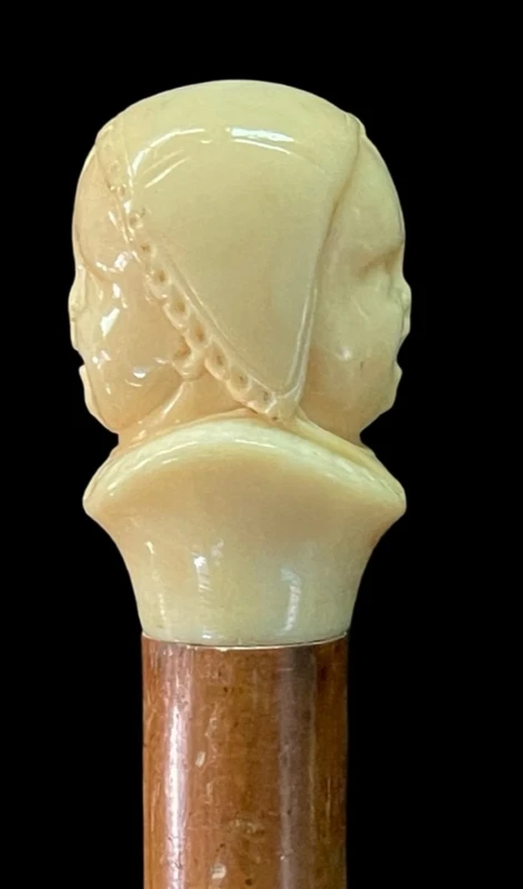 Canne dont le pommeau en ivoire représente le double visage d'un enfant qui rit et qui pleure.