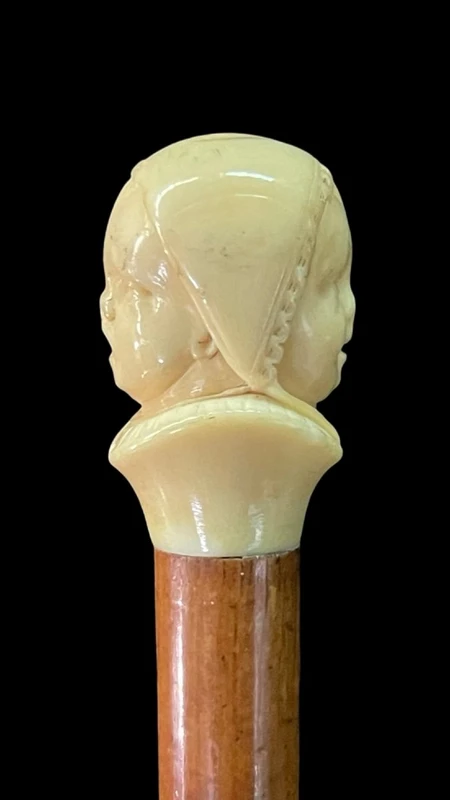 Canne dont le pommeau en ivoire représente le double visage d'un enfant qui rit et qui pleure.