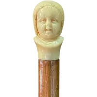 Canne dont le pommeau en ivoire représente le double visage d'un enfant qui rit et qui pleure.