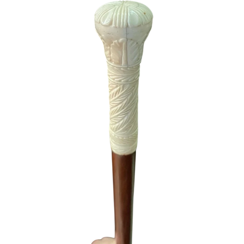 Bastone con pomolo globulare inciso con motivi vegetali e geometrici stilizzati.