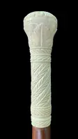 Bastone con pomolo globulare inciso con motivi vegetali e geometrici stilizzati.