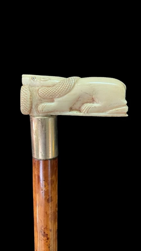 Bastone con impugnatura laterale in avorio raffigurante leone e serpente.