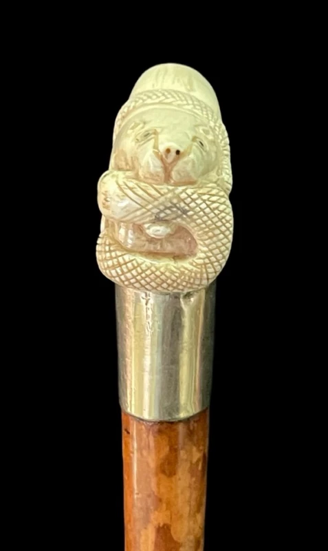 Bastone con impugnatura laterale in avorio raffigurante leone e serpente.