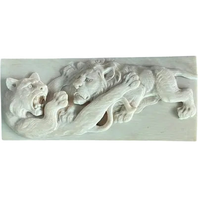 An ivory bas-relief plaque depicting two lions fighting.