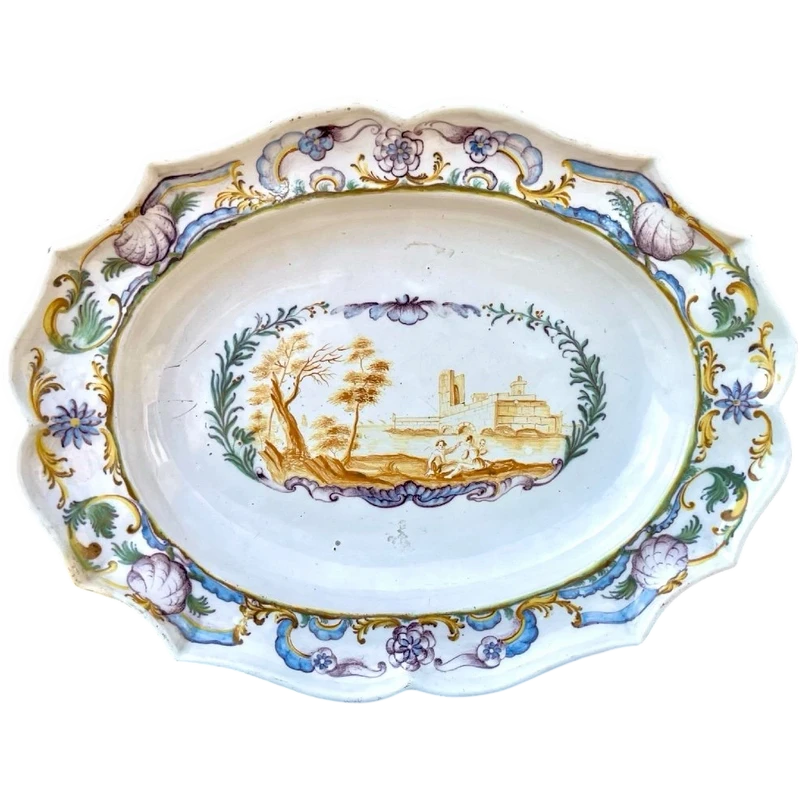 Oval plate with a lobed rim and a border decorated with plant motifs and rocaille.