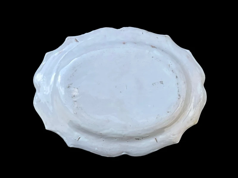 Oval plate with a lobed rim and a border decorated with plant motifs and rocaille.