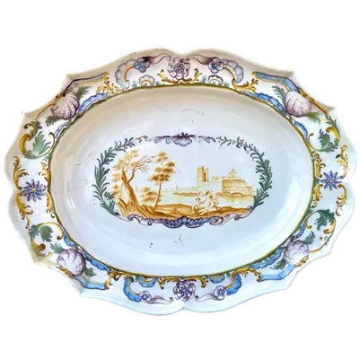 Oval plate with a lobed rim and a border decorated with plant motifs and rocaille.