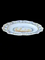 Oval plate with a lobed rim and a border decorated with plant motifs and rocaille.
