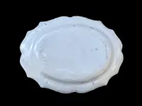 Oval plate with a lobed rim and a border decorated with plant motifs and rocaille.