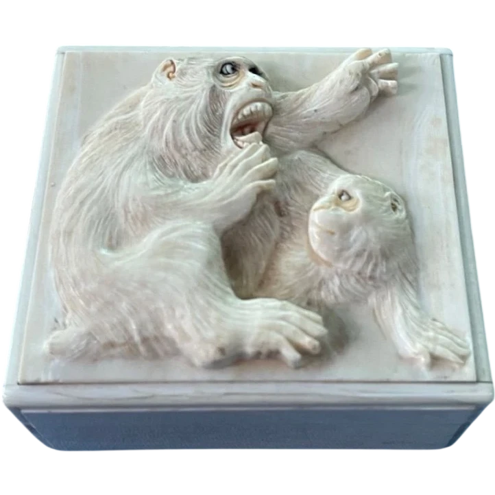 A small ivory box with a lid engraved with two monkeys in high relief.