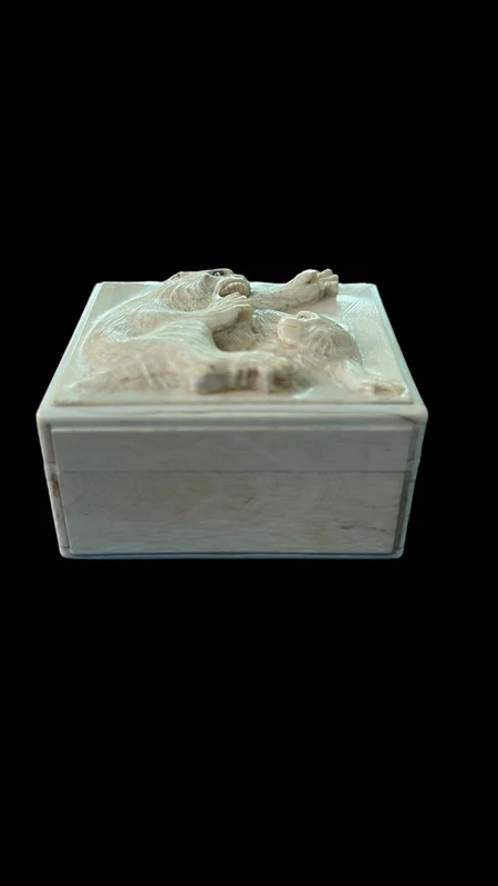 A small ivory box with a lid engraved with two monkeys in high relief.