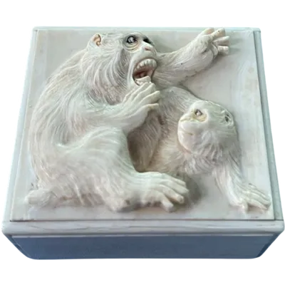 A small ivory box with a lid engraved with two monkeys in high relief.
