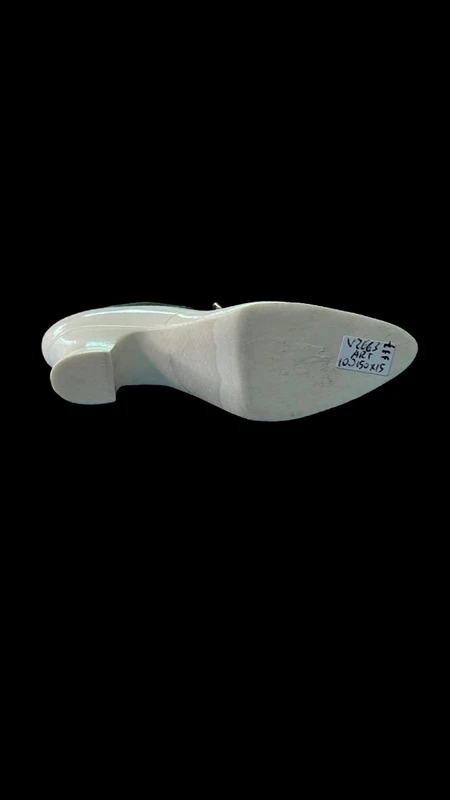Petite chaussure en ivoire servant de porte-épingles. Détail des lacets dorés.
