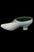Petite chaussure en ivoire servant de porte-épingles. Détail des lacets dorés.