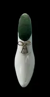 Petite chaussure en ivoire servant de porte-épingles. Détail des lacets dorés.