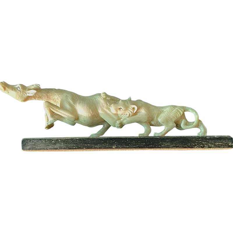 Sculpture en ivoire représentant un lion chassant une antilope.