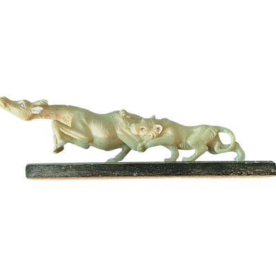 Sculpture en ivoire représentant un lion chassant une antilope.