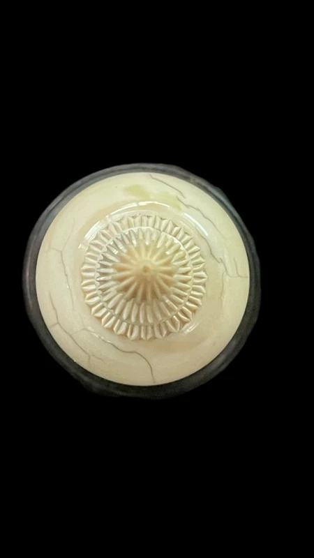 Parfumier sphérique en ivoire orné de motifs géométriques gravés.