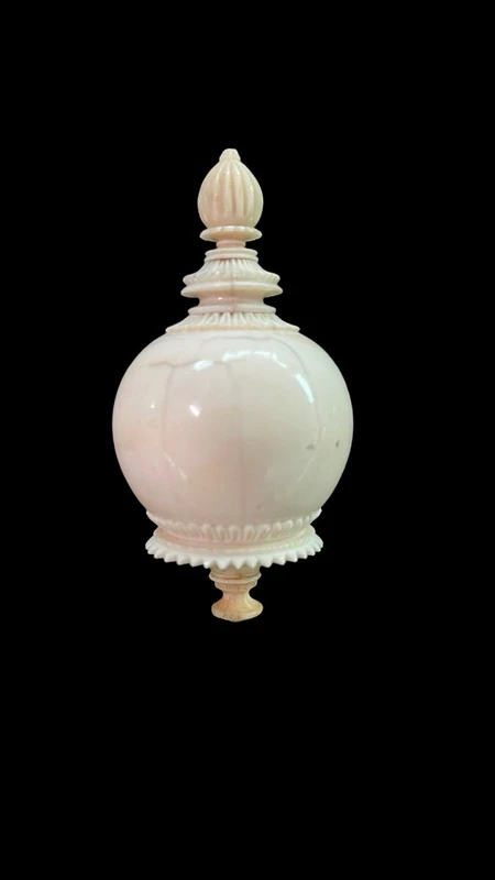 Parfumier sphérique en ivoire orné de motifs géométriques gravés.