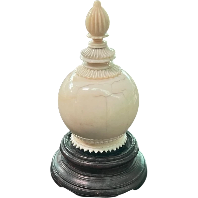 Parfumier sphérique en ivoire orné de motifs géométriques gravés.