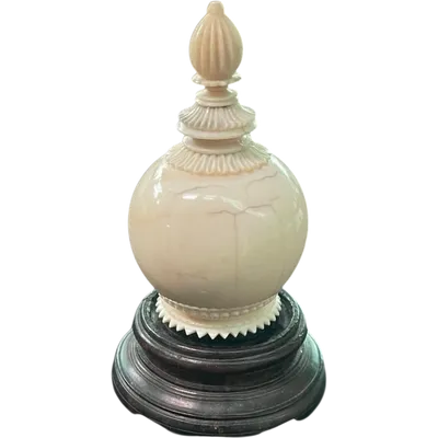 Parfumier sphérique en ivoire orné de motifs géométriques gravés.