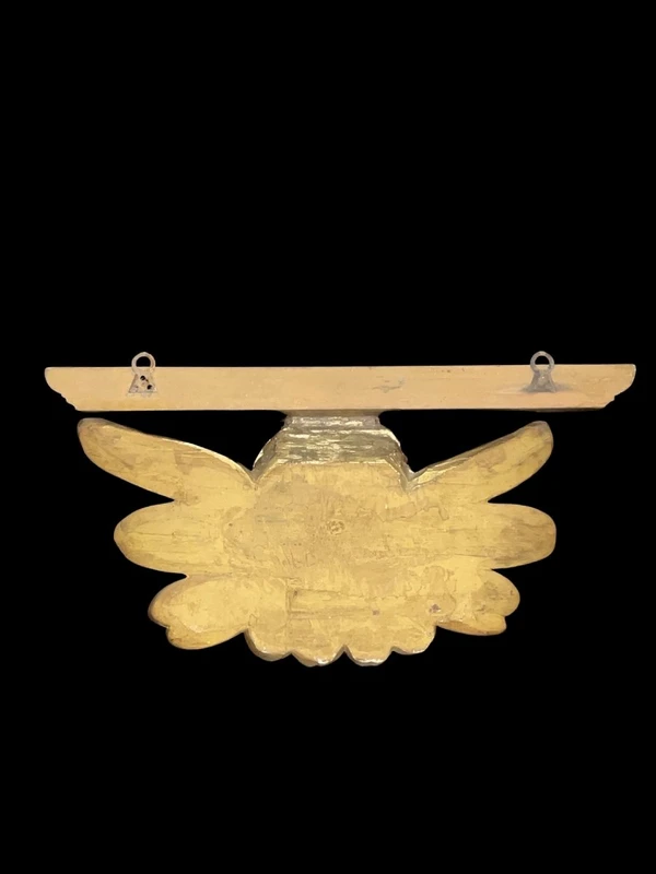 Applique murale en bois sculpté et feuille d'or, ornée d'une tête d'ange chérubin.