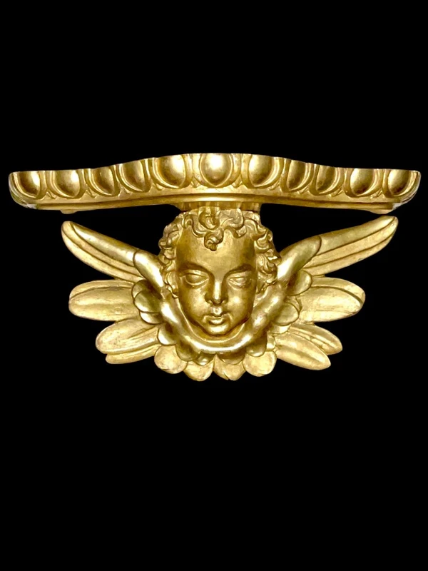 Applique murale en bois sculpté et feuille d'or, ornée d'une tête d'ange chérubin.