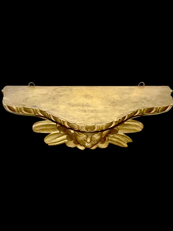 Applique murale en bois sculpté et feuille d'or, ornée d'une tête d'ange chérubin.