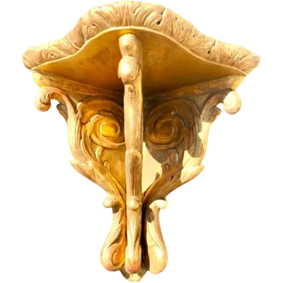 Étagère d'angle en bois sculpté et doré à la feuille, ornée de motifs végétaux stylisés.