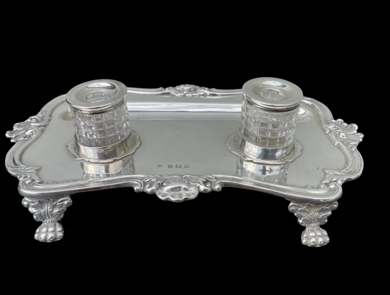 Calamaio in argento a piedi leonini e motivi rocaille e vegetali art nouveau.