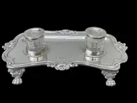 Calamaio in argento a piedi leonini e motivi rocaille e vegetali art nouveau.