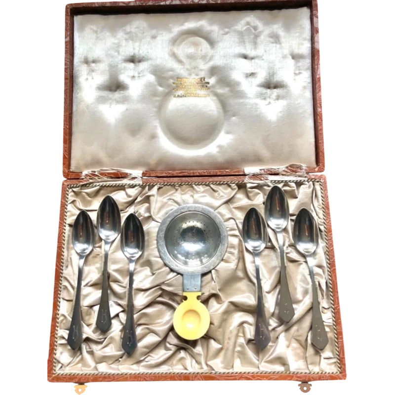 Set of six silver teaspoons with a silver tea strainer engraved with initials