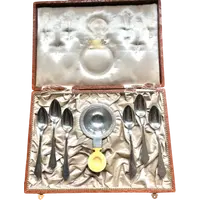 Set of six silver teaspoons with a silver tea strainer engraved with initials