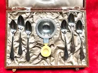Set of six silver teaspoons with a silver tea strainer engraved with initials