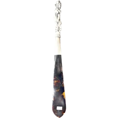 A silver and tortoiseshell letter opener depicting Saint George and the dragon.