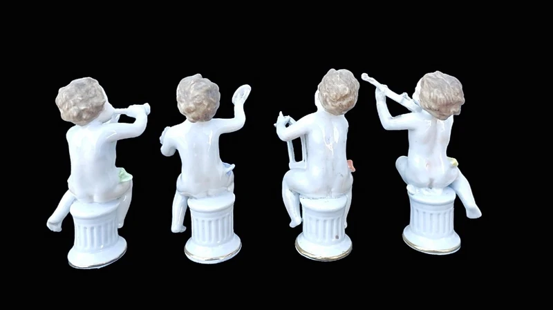A series of four porcelain musicians seated on columns.
