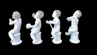 A series of four porcelain musicians seated on columns.