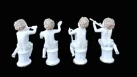 A series of four porcelain musicians seated on columns.