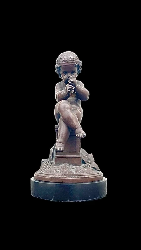 A small bronze sculpture depicting a cherub playing the flute.