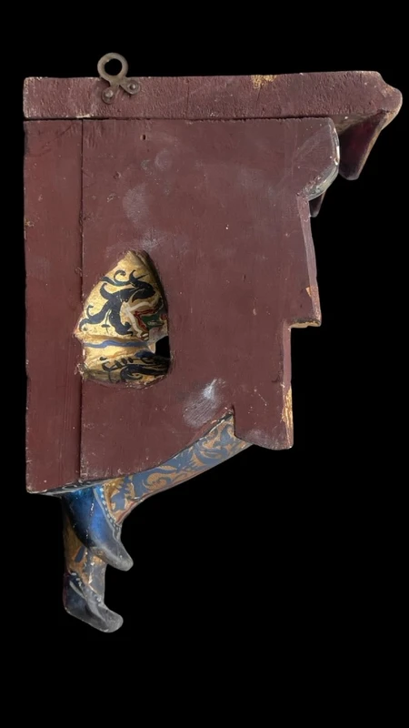 Carved and painted wooden corner shelf with an engraved top and gold-leaf details