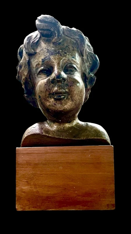 Busto di bambino in legno intagliato e dorato a mecca,montato su base lignea.