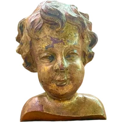 A carved and gilded wooden bust of a child, mounted on a wooden base.