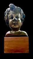Busto di bambino in legno intagliato e dorato a mecca,montato su base lignea.