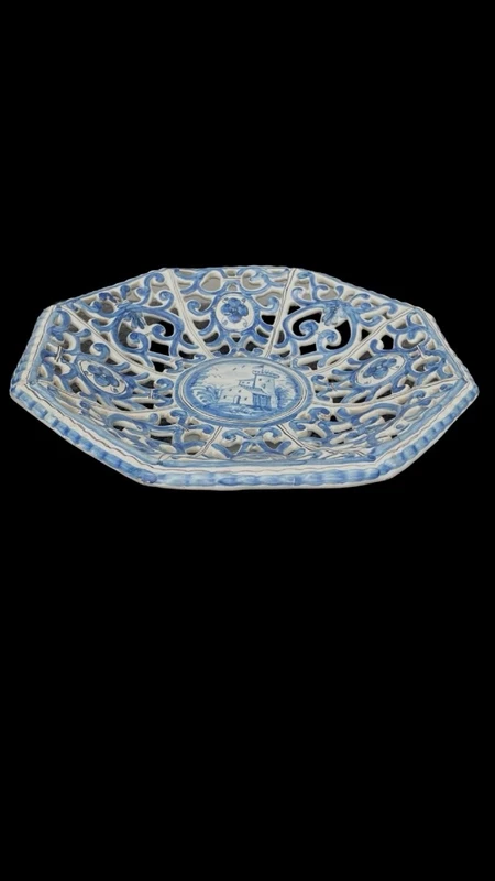 An octagonal plate made of openwork majolica with a monochrome blue rocaille design