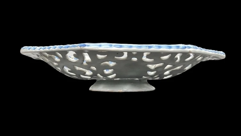 An octagonal plate made of openwork majolica with a monochrome blue rocaille design