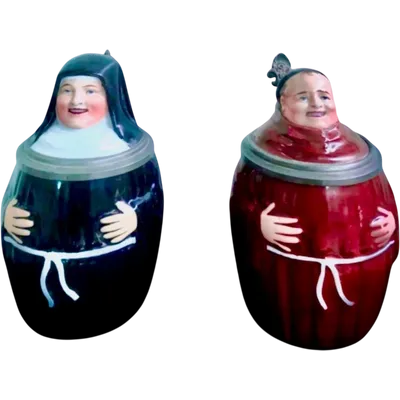 A pair of porcelain and pewter mugs shaped like a priest and a nun