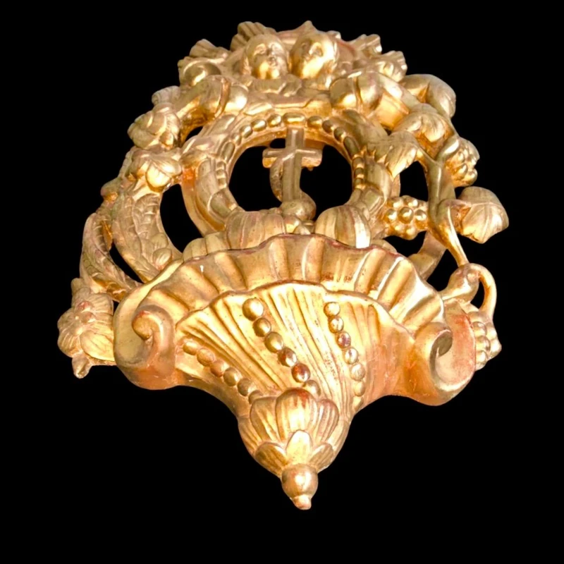 Bénitier en bois et feuille d'or, orné de motifs rocaille, de chérubins, d'épis et de sarments de vigne.