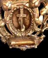 Bénitier en bois et feuille d'or, orné de motifs rocaille, de chérubins, d'épis et de sarments de vigne.