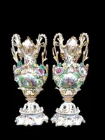 Pair of porcelain vases with two handles, featuring flowers in relief and plant motifs
